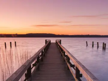 Holzsteg am See bei Sonnenuntergang, ein idyllischer Ort für Badeseen Schleswig-Holstein.